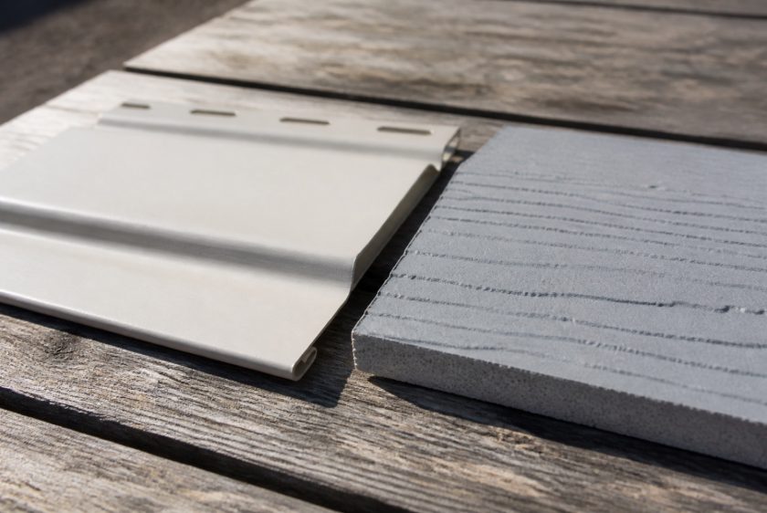 Vinyl and fiber cement siding samples side by side, the biggest factor in siding replacement cost